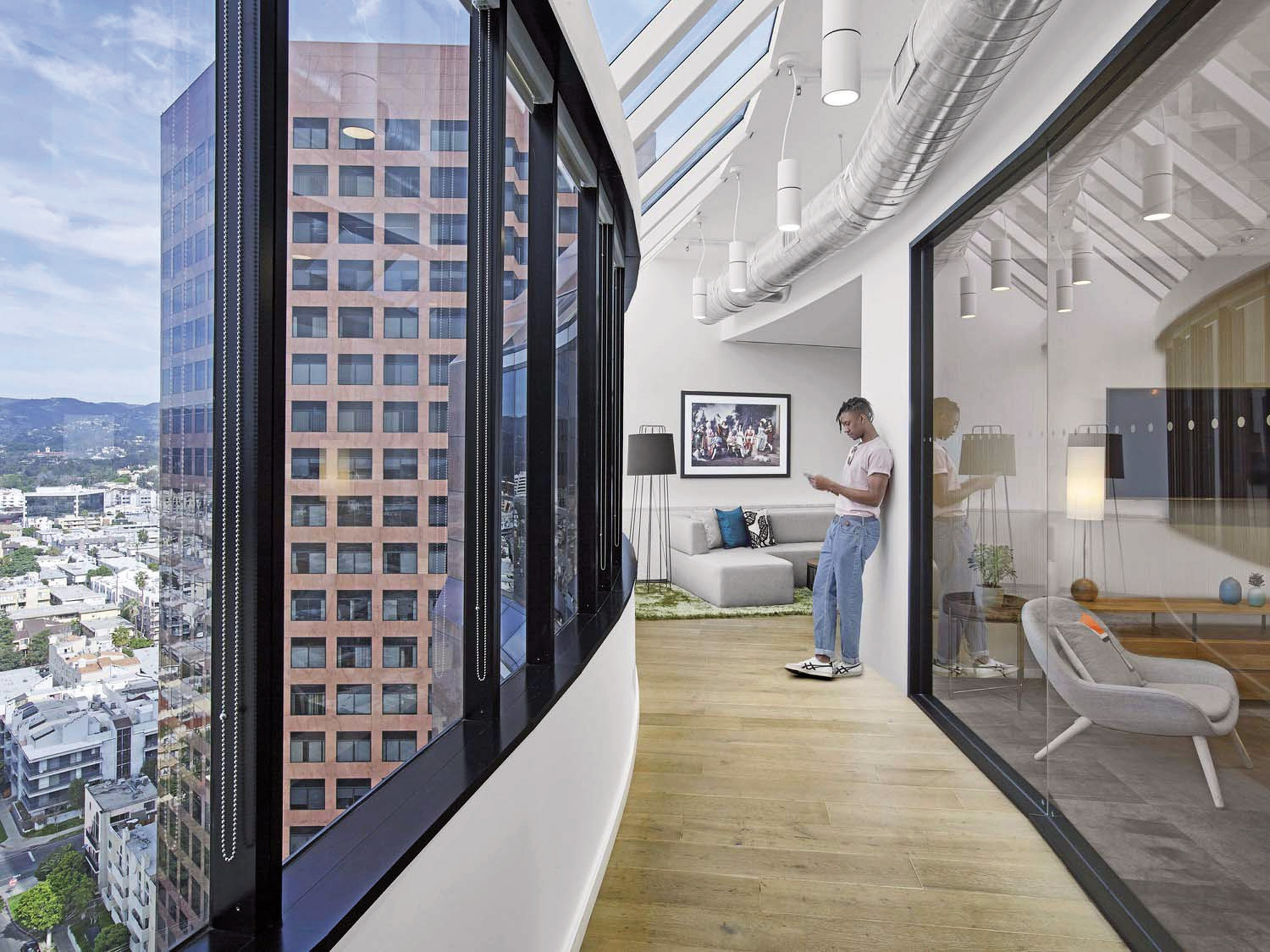 Modern office lounge with expansive cityscape views through floor-to-ceiling windows. Interior features minimalist design with exposed ductwork ceilings, hardwood floors, and a sleek, white armchair. A person stands contemplatively by a digital art display.