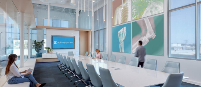 Modern conference room with floor-to-ceiling windows, offering ample natural light. Features a long, sleek white table with ergonomic chairs, and vibrant art on the walls, complementing the room's clean, contemporary design and color scheme.