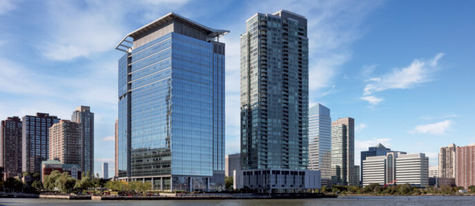 Modern waterfront skyscrapers under clear blue skies with reflective glass facades showcasing a blend of commercial and residential architectural design, set against an urban skyline.