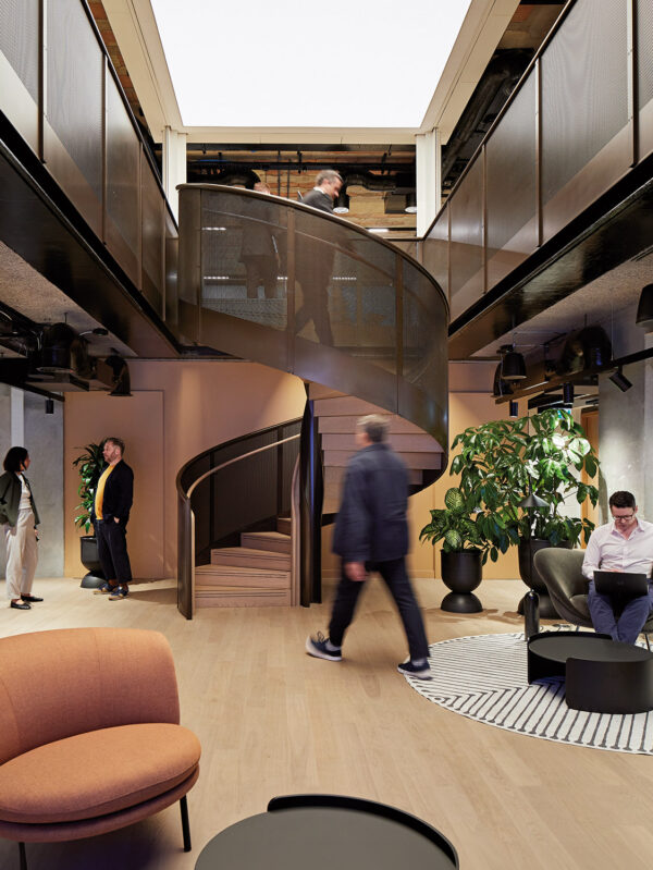 contemporary office featuring a spiral staircase and a large screen displaying a presentation.