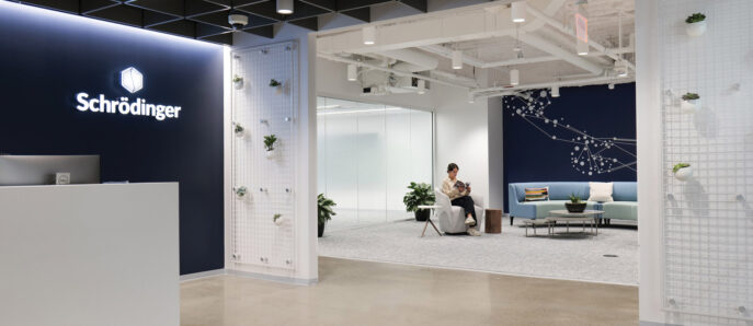 Modern office lobby with exposed ceiling and a backlit corporate logo on the wall. White semi-transparent room dividers reflect a biophilic design, accented with greenery. Comfortable seating areas feature a mix of pastel and neutral tones, promoting a calm and welcoming atmosphere.
